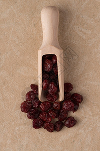 顶端的木制勺子与干红莓相对于米基黑乙烯背景图片
