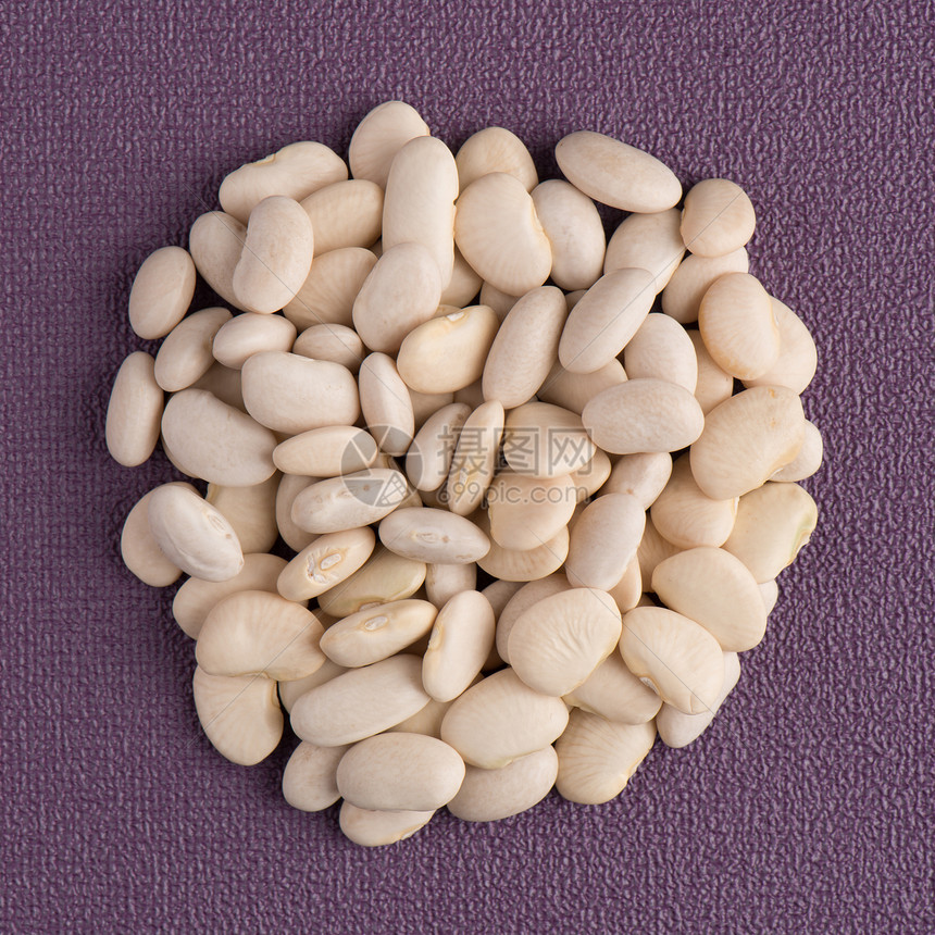 白色豆子的顶端视野紫色黑乙烯基底的白豆圈图片