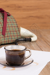咖啡杯纸和侦探帽在老伍德恩桌上图片