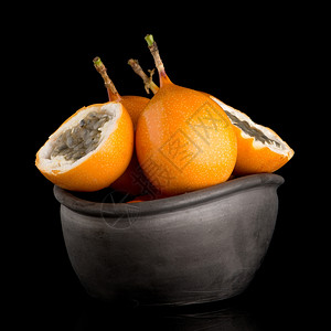 黑底陶瓷碗上底的辣椒果子玛拉奎亚花粉背景图片