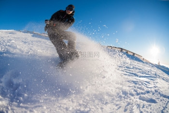 山上坐着滑雪车的骑士面对蓝天的阳光照耀图片