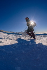 滑雪者在蓝天上穿过深厚的清新雪图片