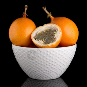 黑底陶瓷白碗上的辣椒水果玛拉奎亚花粉背景图片