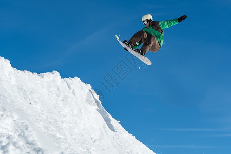 滑雪板运动员滑雪运动员对蓝天进行彻底的跳跃背景