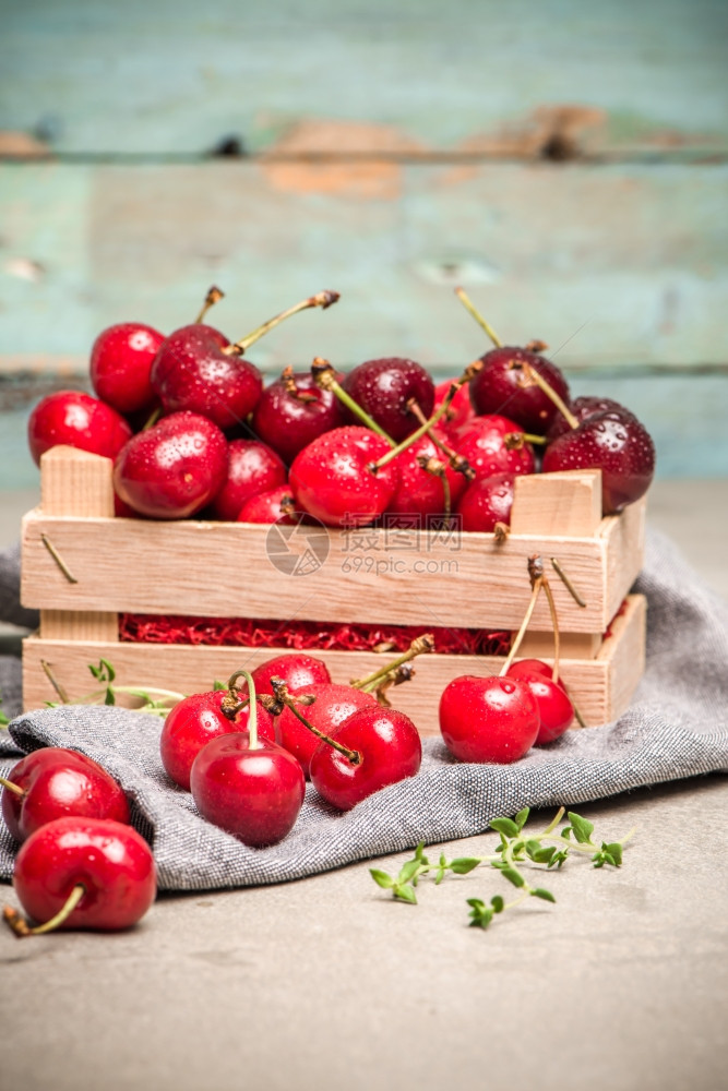 红樱桃放在厨房柜台的小木箱里图片