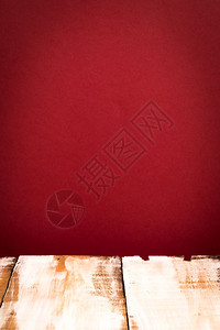 红色墙背景的木桌顶面图片