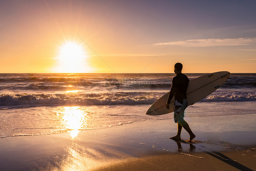 冲浪者在葡萄牙日落时看海浪图片
