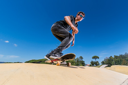滑板机在阳光明媚的夏日在水泵轨道公园练习背景图片