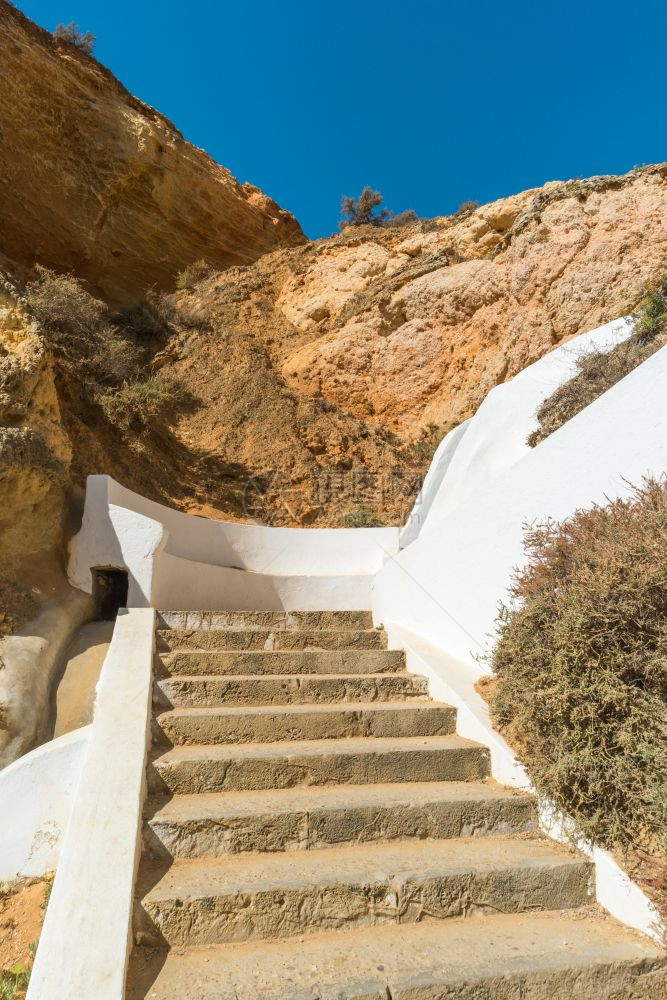 在葡萄牙AlgarSeco的沙石悬崖之间有通往自然海水池的阶梯图片