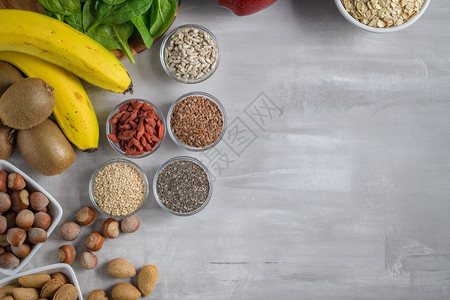 灰色背景的超级食品复制空间坚果豆子绿菜和种健康的素食图片