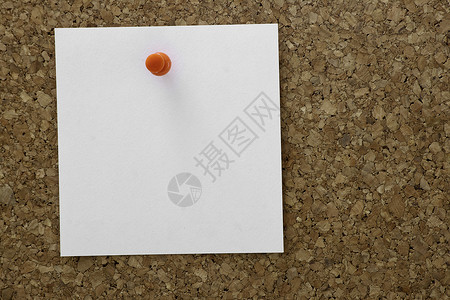 一个简单的棕色软木板上面贴着一张空白纸背景图片