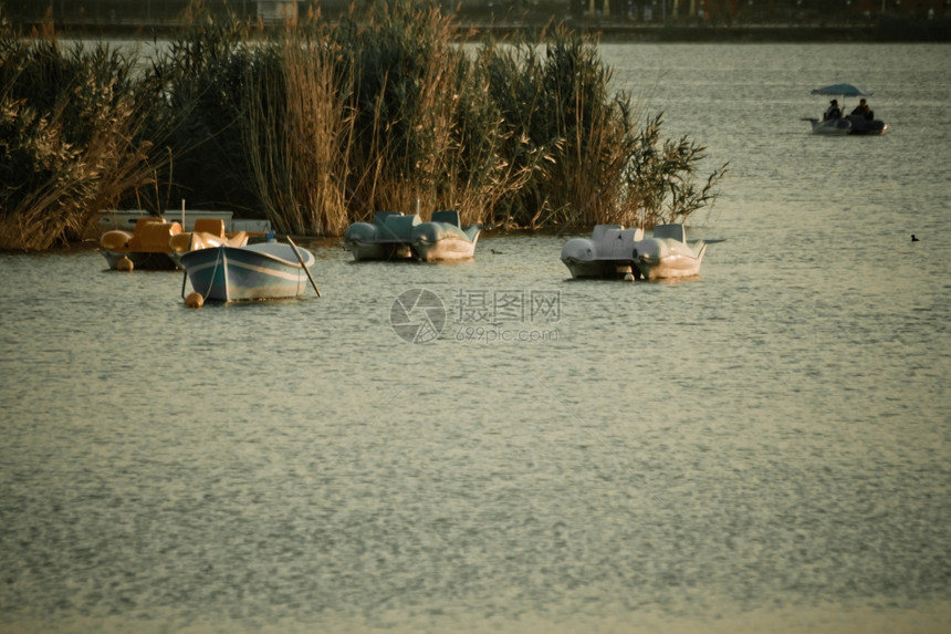 位于土耳其安卡拉Golbasi的Mogan湖草丛前面的Pedalo船和一艘划图片