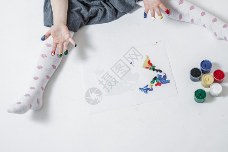 可爱的小女孩用手指涂漆玩和画图片