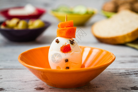 健康的早餐与有趣雪人鸡蛋和胡萝卜的雪人图片