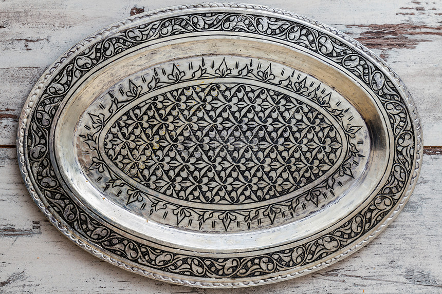 白色木制桌上土耳其传统银盘图片