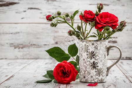 白银装饰杯中美丽的新红玫瑰背景图片