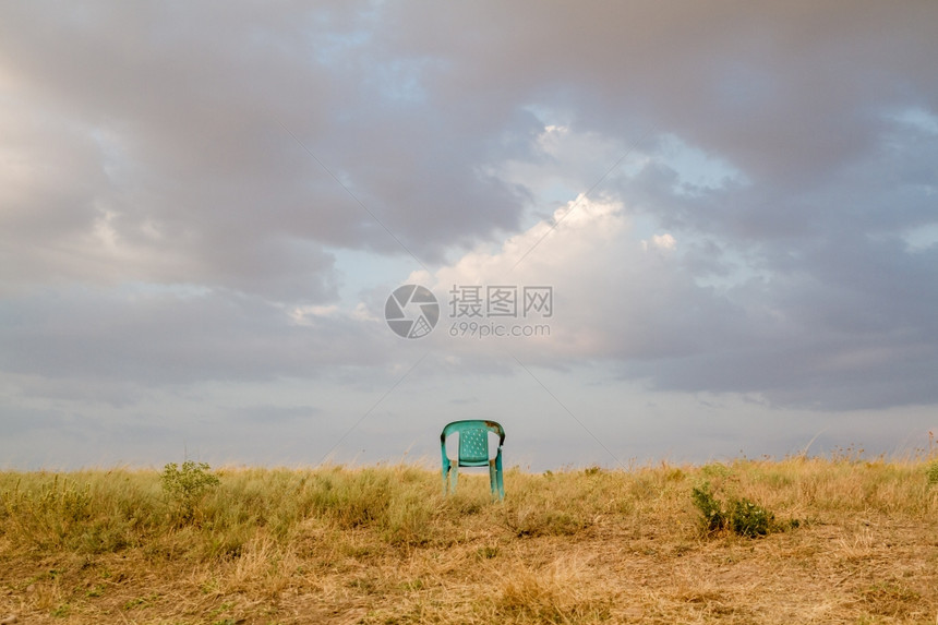 废弃在田地的GrungiRefor损坏的塑料绿色椅子图片