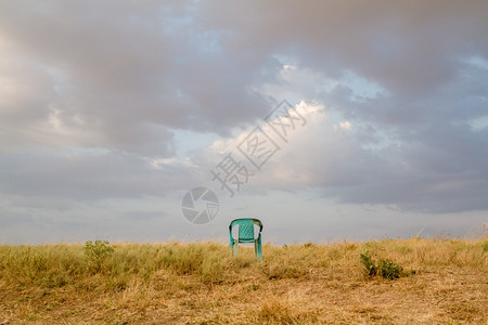 废弃在田地的GrungiRefor损坏的塑料绿色椅子图片