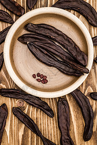 木质背景上的一组干角豆荚高清图片