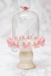 白大理石上粉红色蝴蝶设计的空铃罐图片