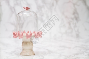 白大理石上粉红色蝴蝶设计的空铃罐图片