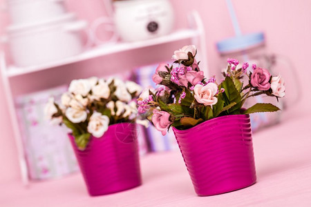 粉红木本底色花盆中的人工粉红花图片