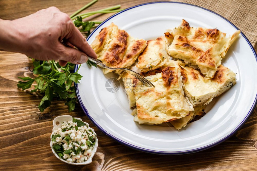 自制美味的土耳其式奶酪派搪瓷盘木质背景图片