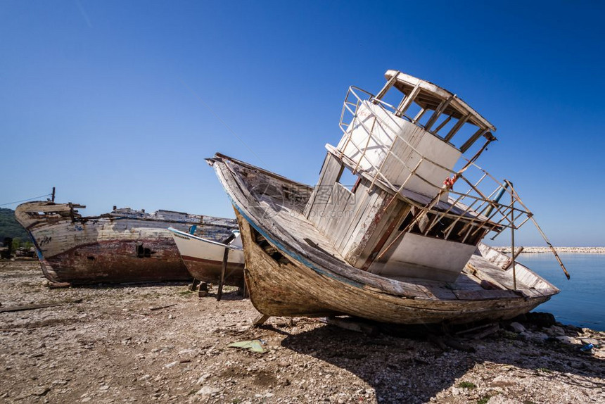 遗弃在岸边的旧渔船图片