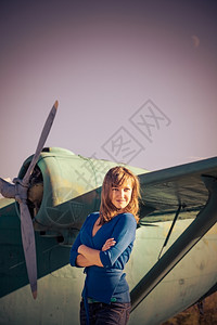 女孩站在旧飞机旁摆姿势图片