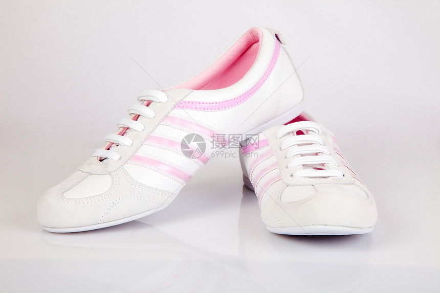 一对白色和粉运动鞋在白背景上图片