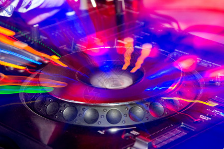 迪斯科转盘DJ站在夜总会的光辉中背景