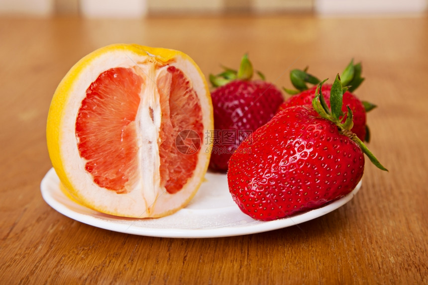 木质表面的成熟草莓水果背景图片