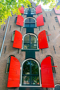阿姆斯特丹运河上的老房子阿姆斯特丹多层传统荷兰房子有红色百叶窗图片
