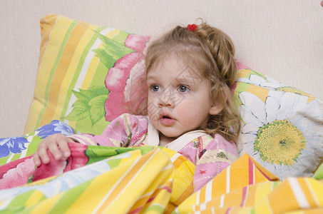 两岁女孩躺在床上枕头放墙盖光亮的毯子家具图片
