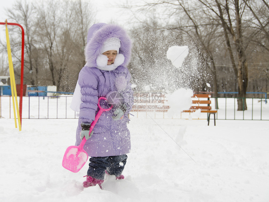 4岁的女孩用雪铲来铲雪图片