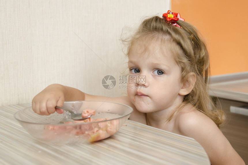 小女孩坐在厨房里喝粥图片