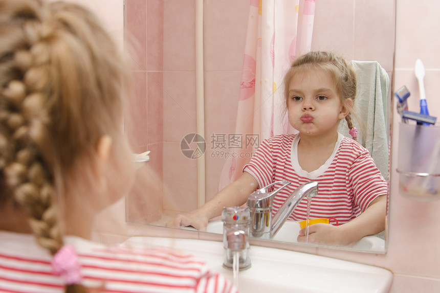 4岁女孩刷牙后洗她看着镜子浴室图片