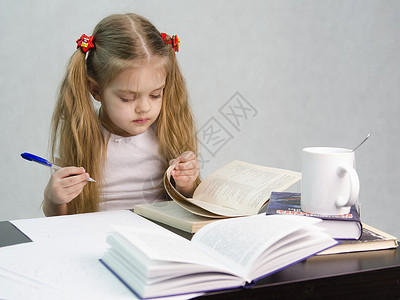 女孩坐着翻书写作业背景图片