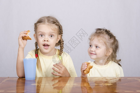 两个孩子坐在桌上吃早餐图片