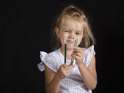 分化的女孩拿着一对指南针和铅笔看着指南针工作室黑色背景图片