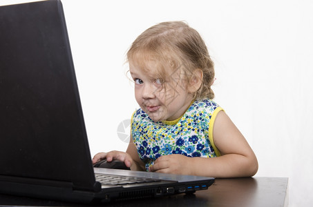在笔记本电脑上工作的女孩笔记本电脑站在桌上背景图片
