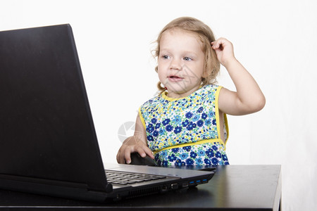 在笔记本电脑上工作的女孩笔记本电脑站在桌上图片