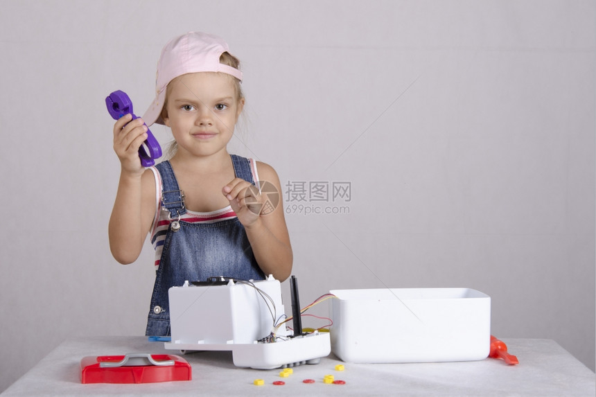 女孩在修理机和玩具微波炉中耍女孩拿着一对钳子看框架图片