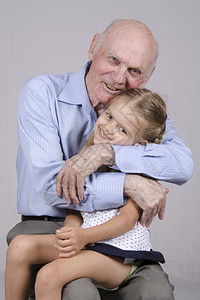一个八十岁的老人肖像坐在孙女身边的男子四岁人拥抱一个女孩图片