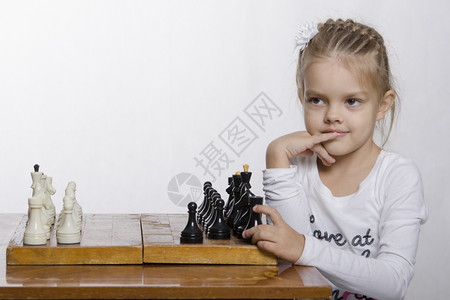 坐在桌子上的女孩站在象棋局的桌子上图片