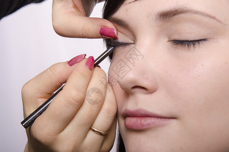 化妆师在模型39上做化妆品她画了眼睫毛模型背景图片
