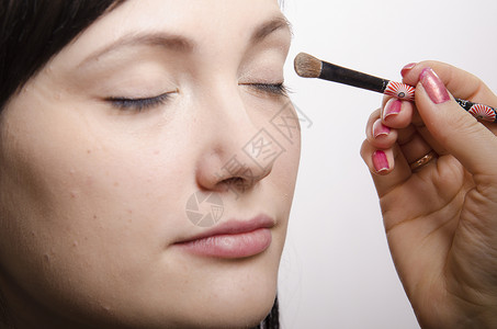 画睫毛化妆师在模型Q39上做化妆品脸她画上层眼皮模型的阴影背景