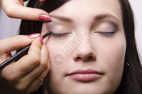 眼线笔化妆师在模型Q39上做化妆品脸她画上层眼皮模型的阴影背景