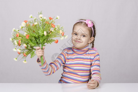 女孩坐在桌子上带着一束人工花背景图片
