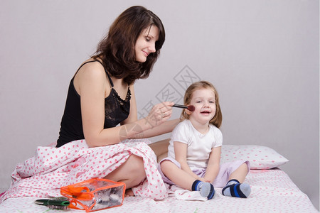 母亲和女儿在床上梳头发图片